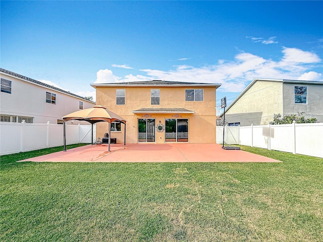 back of property featuring a lawn, a patio area, and stucco siding