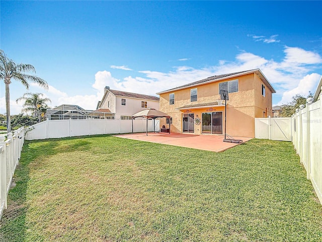 back of house featuring a yard, a fenced backyard, stucco siding, and a patio