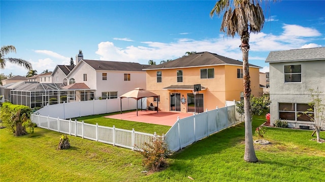 back of house with a lawn, a patio area, a fenced backyard, and stucco siding