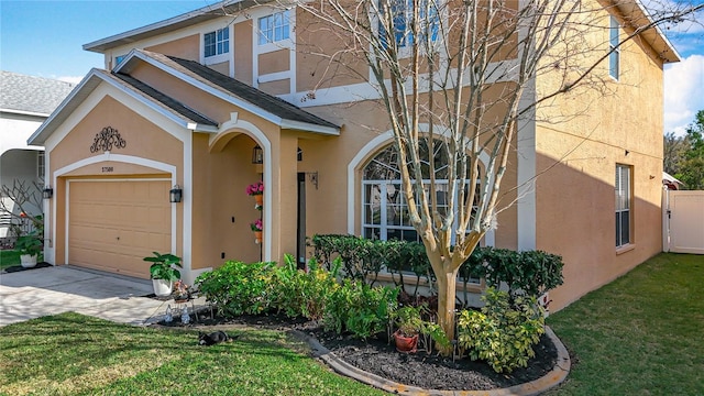 view of front of property featuring a garage, driveway, a front lawn, and stucco siding