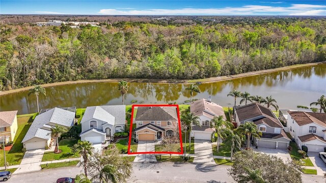 aerial view with a water view, a view of trees, and a residential view