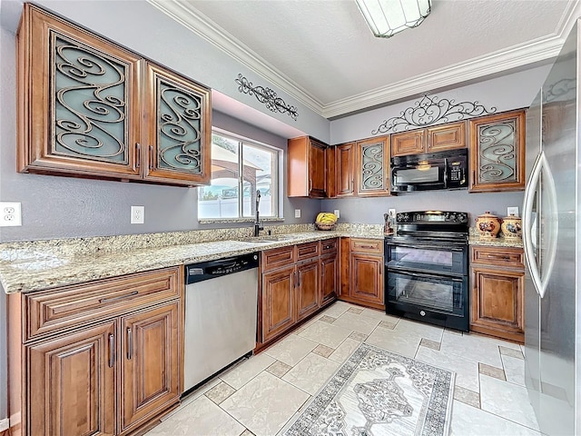 kitchen with brown cabinets, a sink, black appliances, stone tile flooring, and ornamental molding
