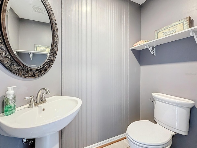 bathroom featuring a sink, toilet, and visible vents