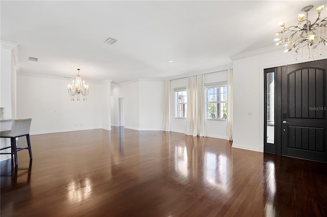 foyer featuring dark wood-type flooring, crown molding, and a notable chandelier