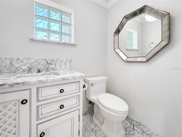 bathroom with toilet, vanity, and crown molding