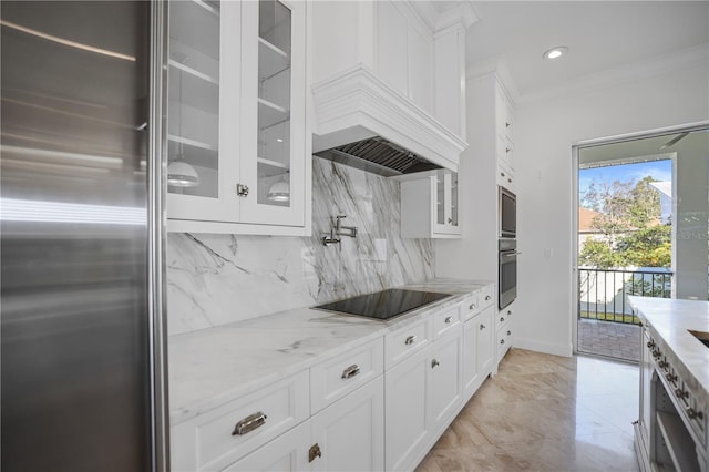 kitchen with white cabinetry, appliances with stainless steel finishes, decorative backsplash, light stone countertops, and crown molding