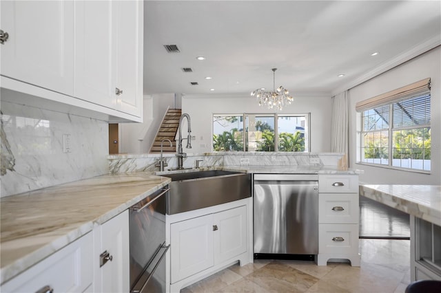 kitchen with white cabinets, sink, a chandelier, light stone counters, and stainless steel dishwasher