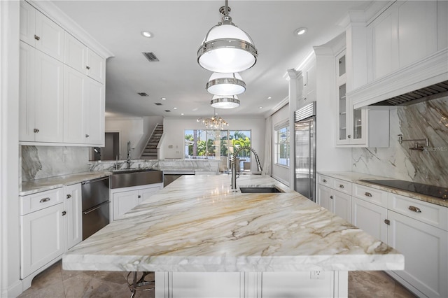 kitchen with appliances with stainless steel finishes, decorative backsplash, a spacious island, a kitchen breakfast bar, and sink