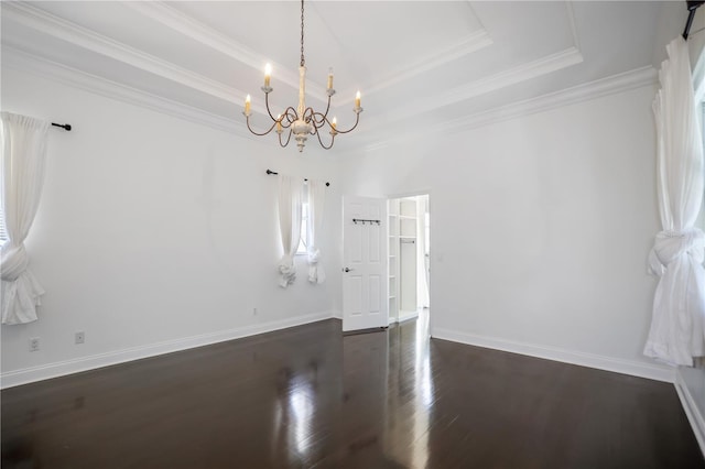 unfurnished room featuring a raised ceiling, dark hardwood / wood-style floors, a chandelier, and ornamental molding