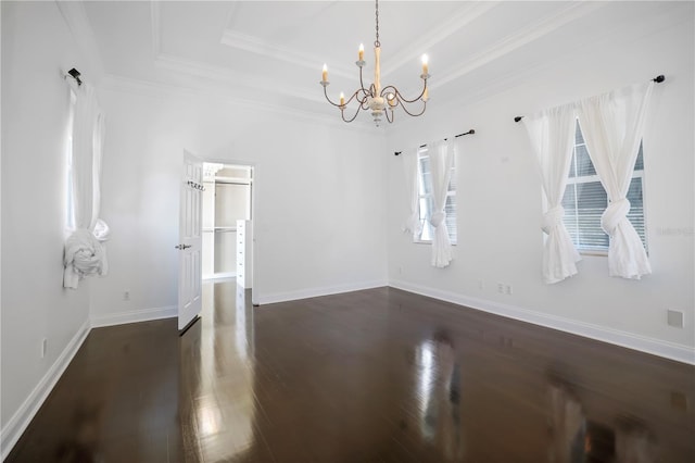 interior space with ornamental molding, dark hardwood / wood-style floors, a tray ceiling, and a notable chandelier