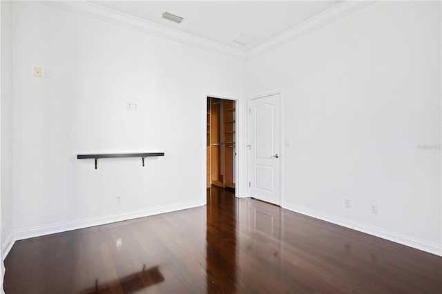 empty room featuring crown molding and dark hardwood / wood-style floors