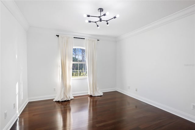 spare room featuring an inviting chandelier, dark hardwood / wood-style flooring, and crown molding