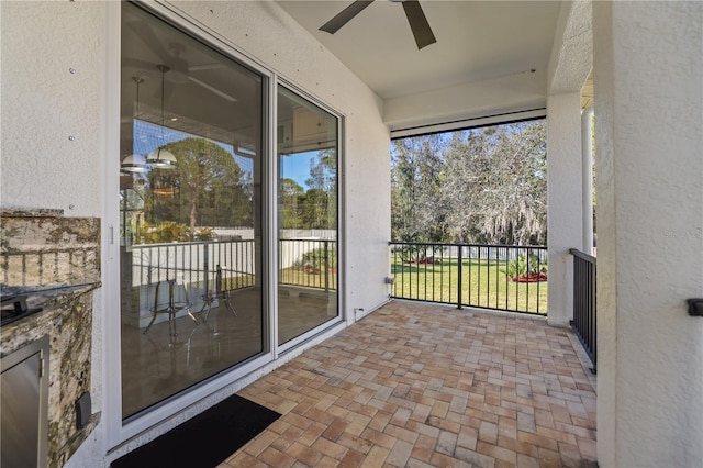 unfurnished sunroom featuring ceiling fan