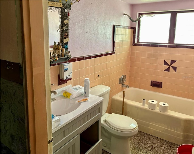 bathroom featuring vanity, toilet, a bathing tub, and tile walls