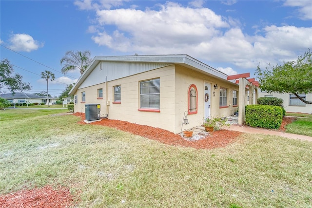 view of front of home with central AC and a front yard