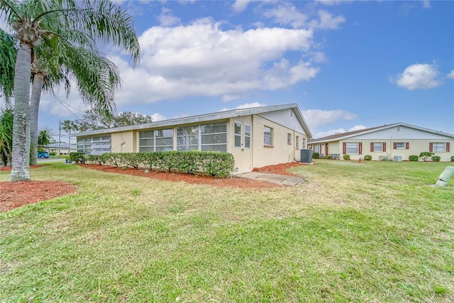 view of side of home with cooling unit and a lawn