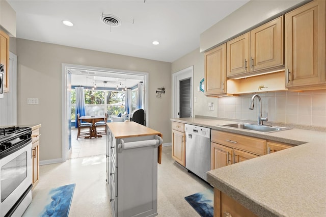 kitchen with light brown cabinetry, sink, backsplash, and appliances with stainless steel finishes