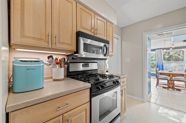 kitchen with light countertops, stainless steel appliances, decorative backsplash, and light brown cabinetry