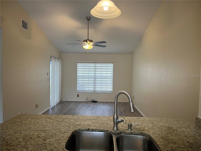 kitchen with lofted ceiling, ceiling fan, sink, dark hardwood / wood-style flooring, and light stone counters