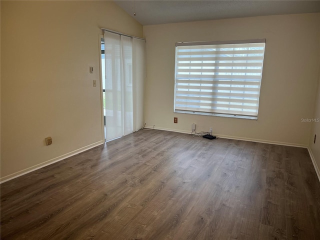 unfurnished room featuring vaulted ceiling and dark wood-type flooring