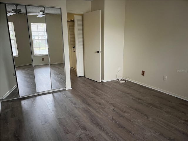 unfurnished bedroom with a textured ceiling, dark hardwood / wood-style flooring, and a closet