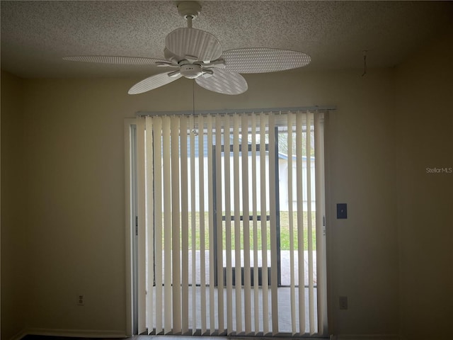 empty room with ceiling fan and a textured ceiling