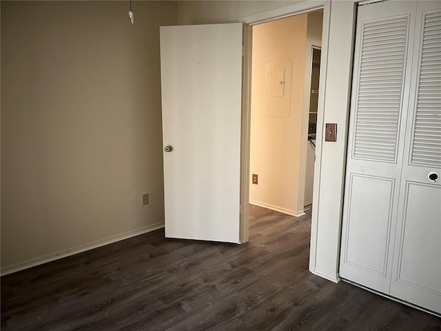 unfurnished bedroom featuring dark hardwood / wood-style flooring and a closet