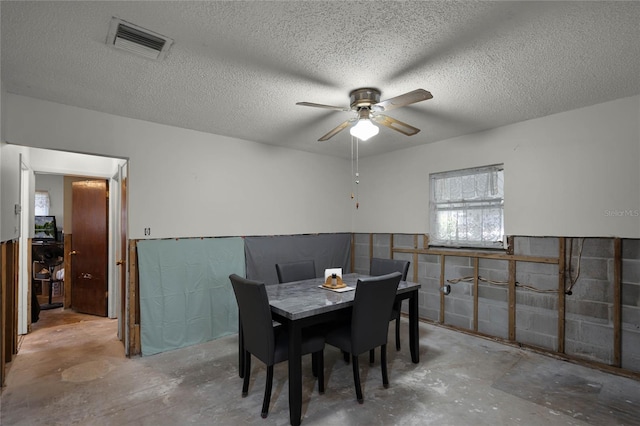 dining space with a textured ceiling, concrete flooring, and ceiling fan