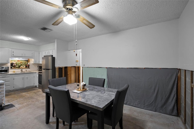 dining room featuring ceiling fan, a textured ceiling, and sink