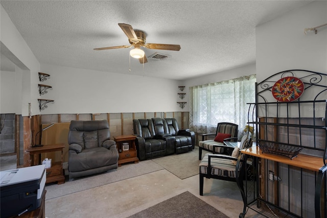 living room featuring a textured ceiling and ceiling fan