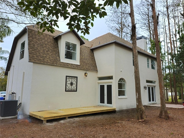 rear view of property featuring french doors and cooling unit