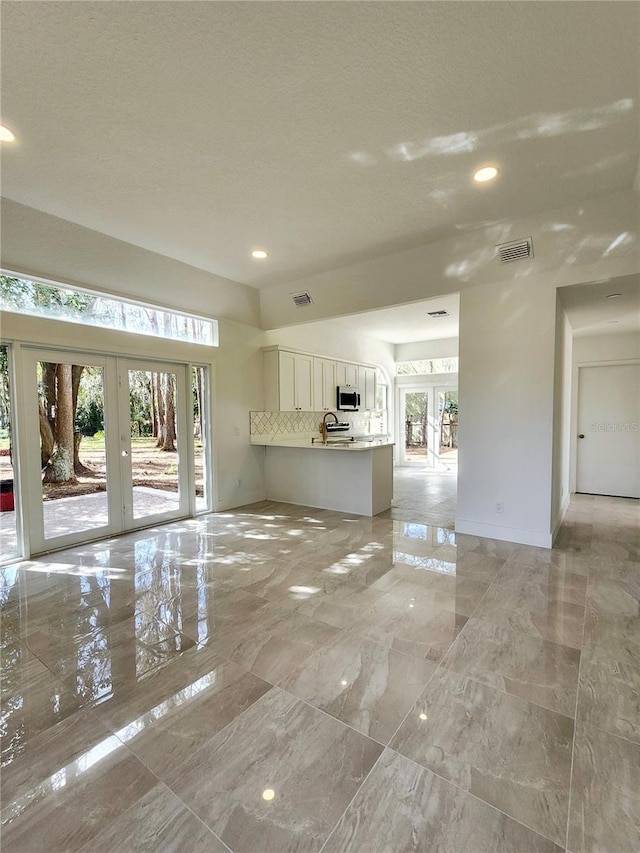 unfurnished living room with french doors and sink