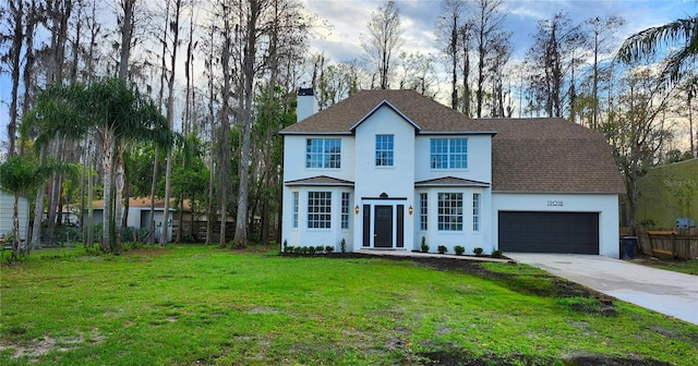 view of front of home with a chimney, an attached garage, a front yard, fence, and driveway