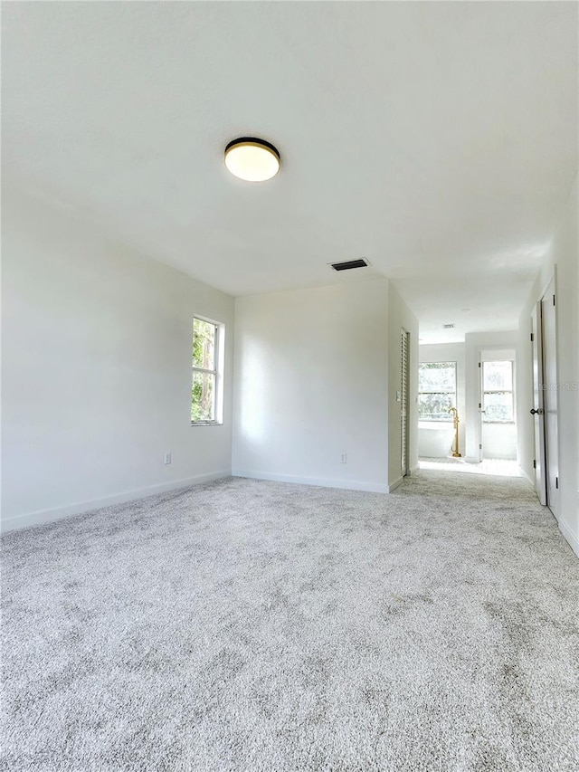 empty room featuring carpet floors and baseboards