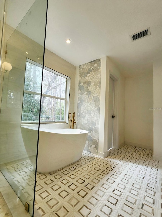 full bathroom featuring recessed lighting, visible vents, baseboards, a soaking tub, and wallpapered walls