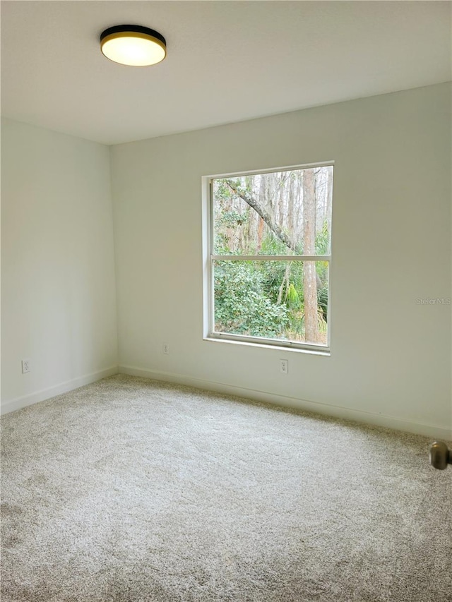 unfurnished room featuring carpet flooring and baseboards