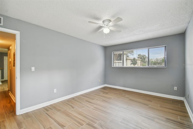 empty room featuring a textured ceiling, ceiling fan, and light wood-type flooring