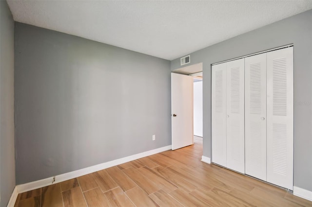 unfurnished bedroom with a closet and a textured ceiling