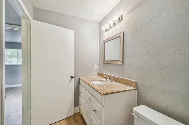 bathroom featuring toilet, wood-type flooring, and vanity