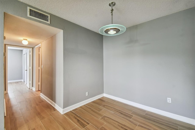 unfurnished dining area featuring a textured ceiling