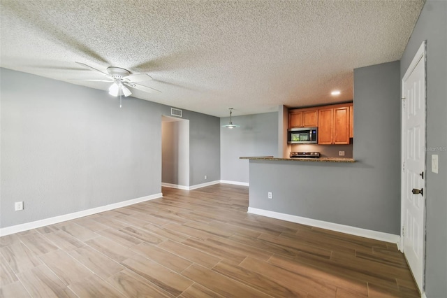 unfurnished living room featuring a textured ceiling, ceiling fan, and light hardwood / wood-style flooring