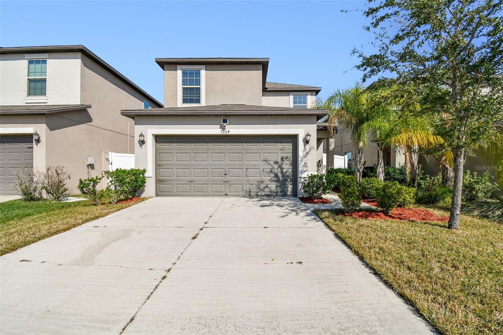 front of property featuring a front lawn and a garage