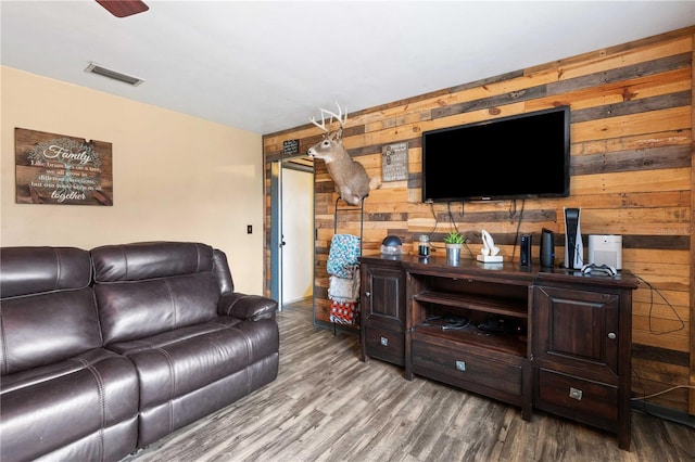 living room with hardwood / wood-style flooring and wooden walls