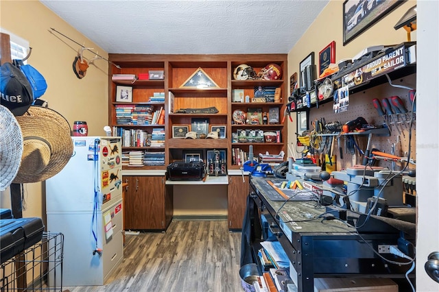 home office with wood-type flooring and a textured ceiling