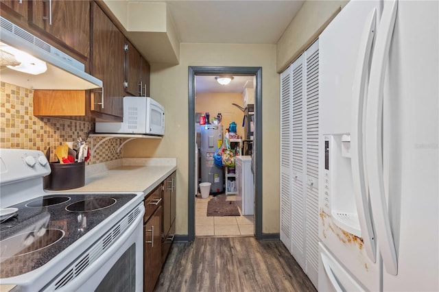 kitchen with white appliances, water heater, backsplash, dark brown cabinets, and dark hardwood / wood-style floors