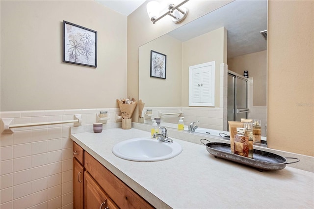 bathroom with vanity, tile walls, and walk in shower