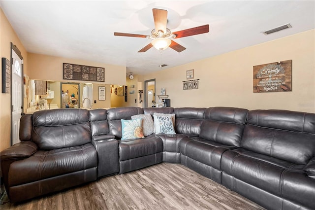 living room featuring wood-type flooring and ceiling fan