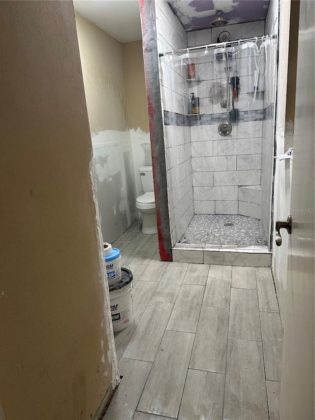 bathroom with toilet and tiled shower