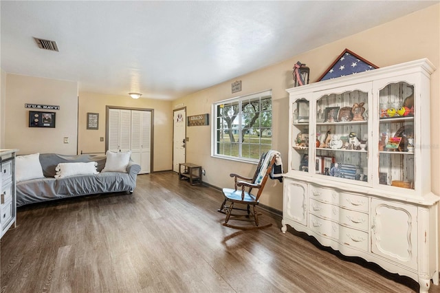 bedroom featuring baseboards, a closet, visible vents, and wood finished floors