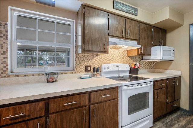 kitchen with white appliances, extractor fan, decorative backsplash, and light countertops